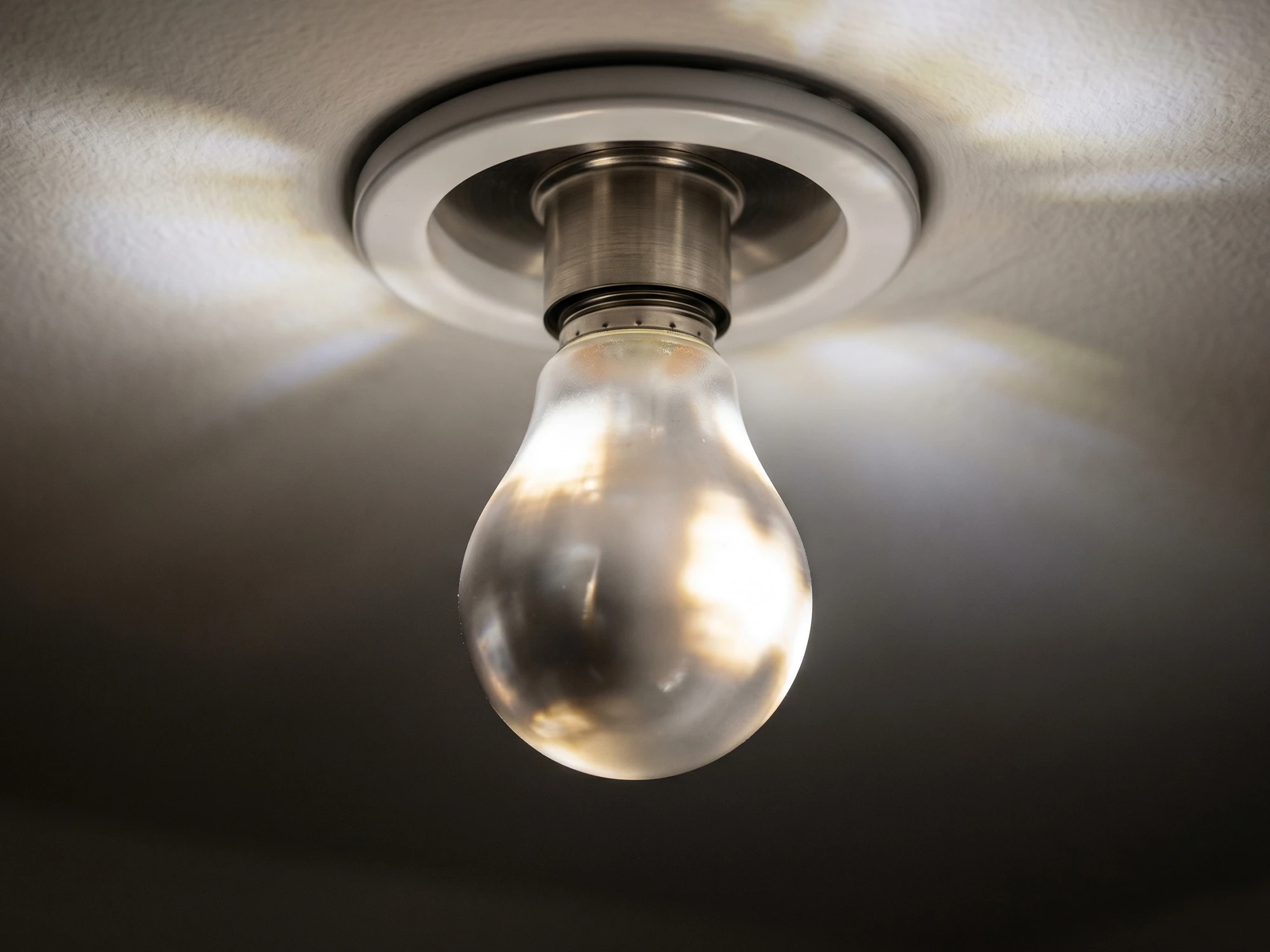 LED Lamba Neden Yanıp Söner? 7 Sebep ve Çözüm Tavandaki LED ampul yakın çekim, ışığın hafif titremesi anında çekilmiş görsel | Levent Elektrik
